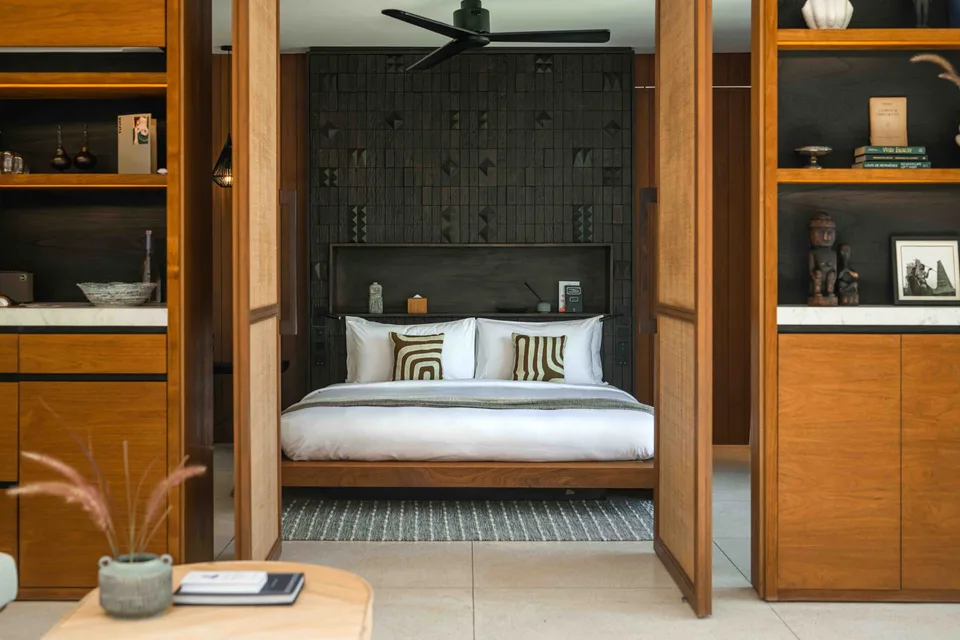 Timber-framed bedroom with patterned textiles at Cap Karoso, Sumba