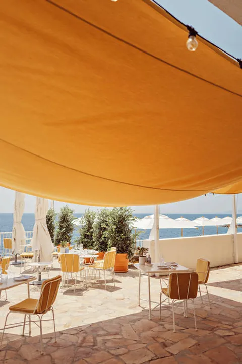 Sea-facing tables at Estelo restaurant at Les Roches Rouges