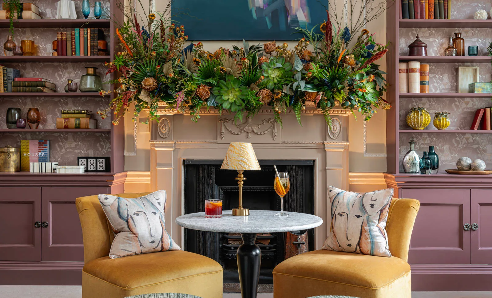 Fireplace, armchairs and botanical displays in a drawing room at The Royal Crescent Hotel & Spa