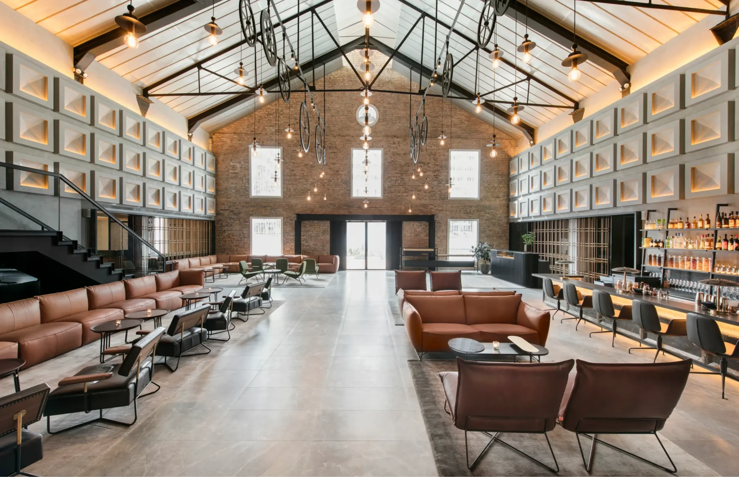 The Warehouse Hotel lobby and bar beneath exposed roof trusses and pendant lights