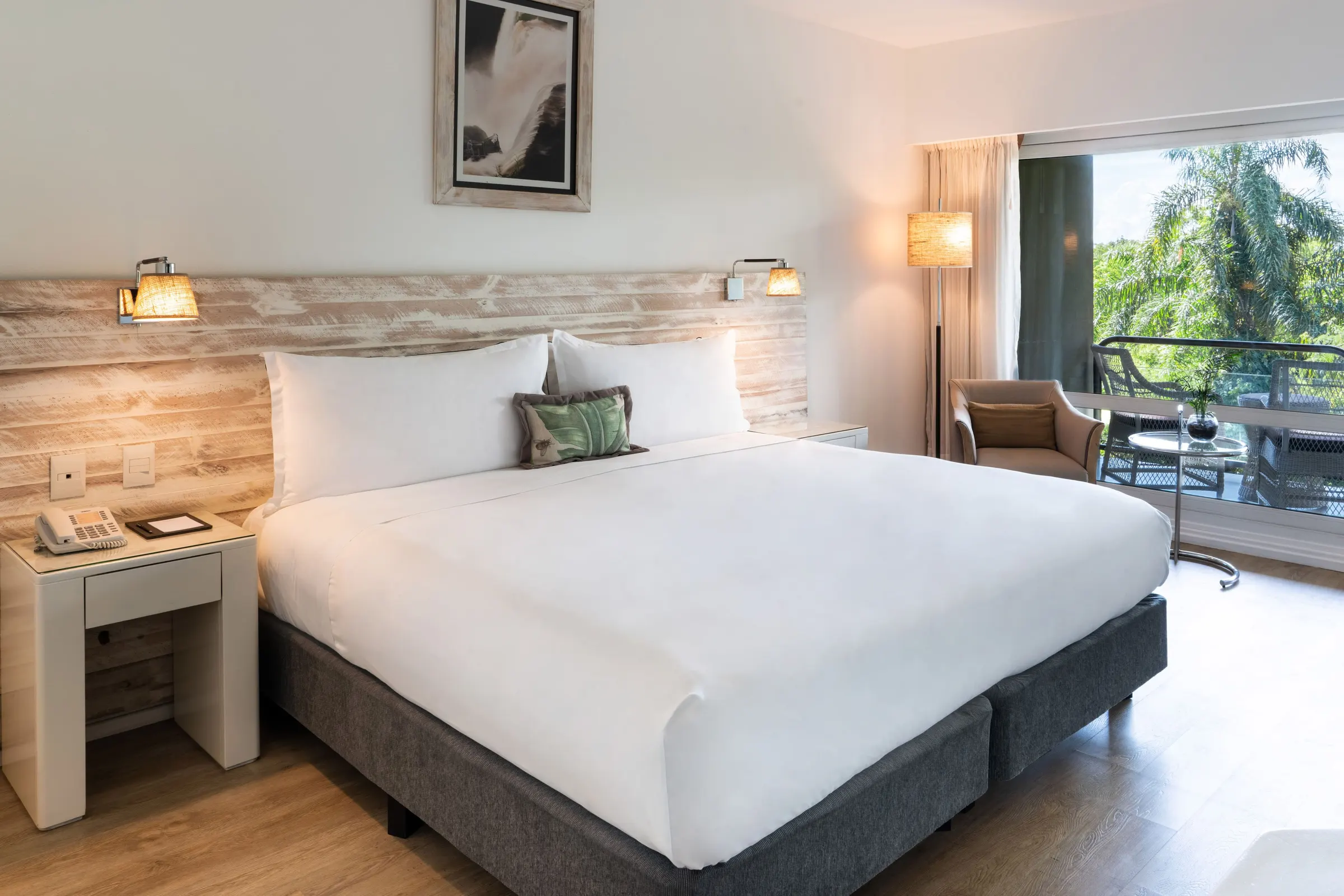 Guest bedroom opening to a green balcony view at Gran Meliá Iguazú
