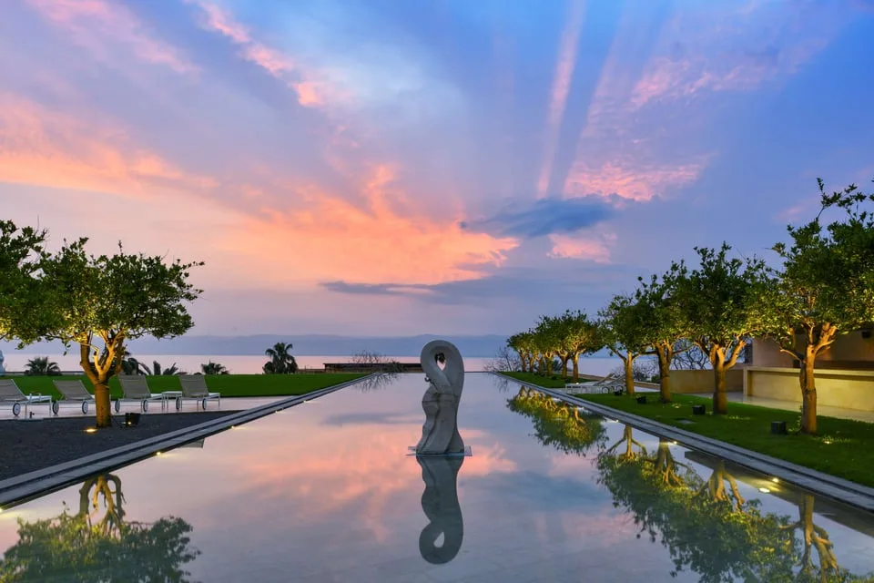 Reflecting pool, palms and sunset at Kempinski Hotel Ishtar Dead Sea