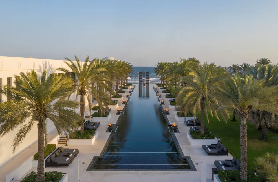 Palm-lined Long Pool leading towards the sea at The Chedi Muscat