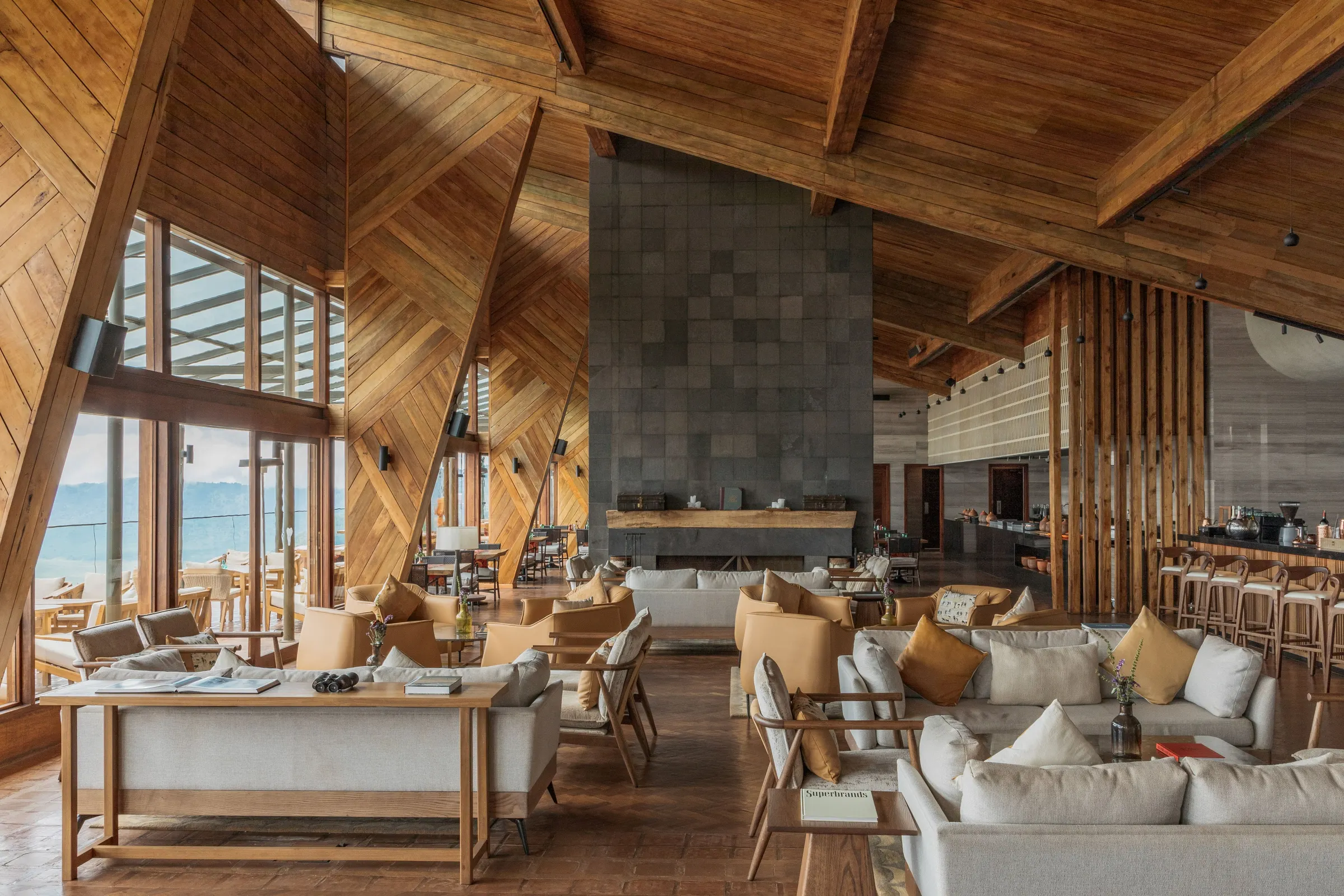 Wood-panelled Crater Bar lounge and stone fireplace at Ngorongoro Lodge