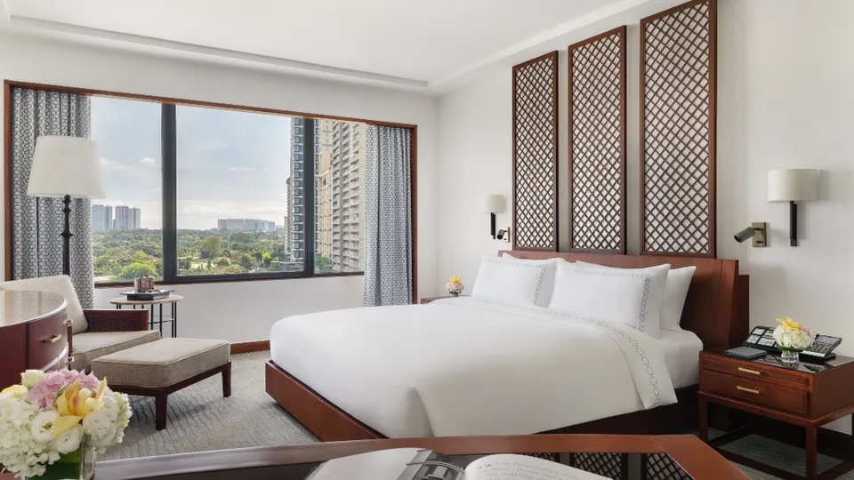 Executive Suite bedroom with lattice panels and city views at The Peninsula Manila