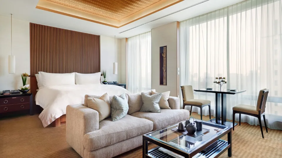 Warm timber details and cream seating in a Deluxe Room at The Peninsula Tokyo